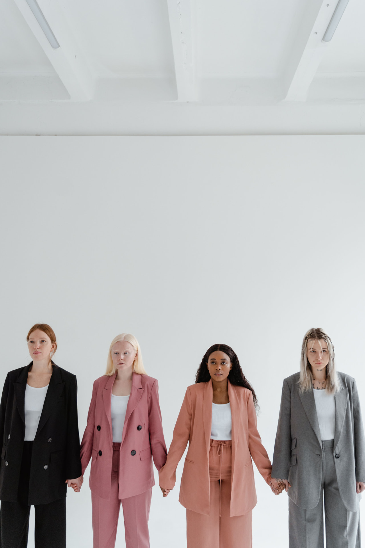Vier Frauen stehen Hand in Hand nebeneinander
