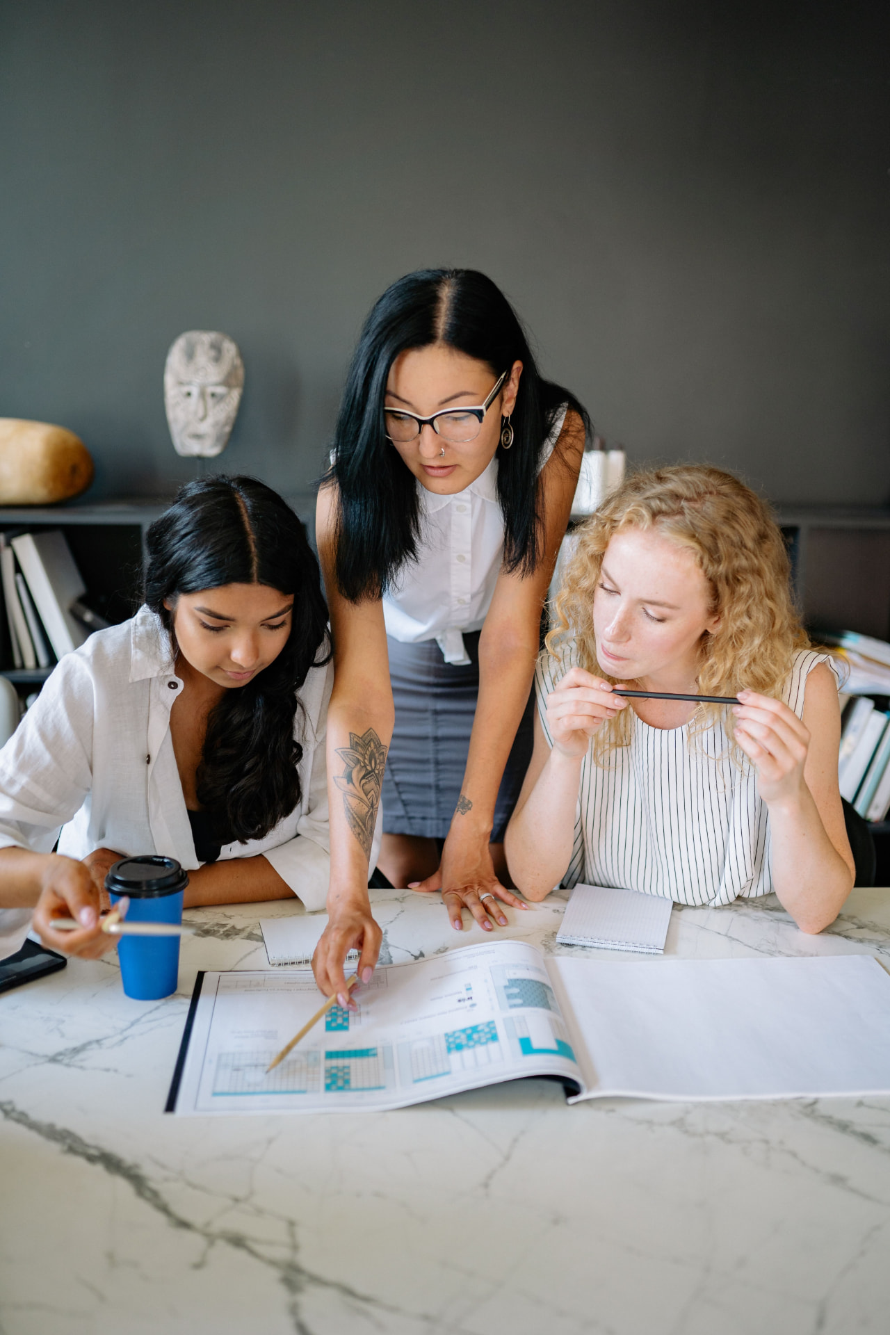 Drei Frauen arbeiten gemeinsam an einem Tisch